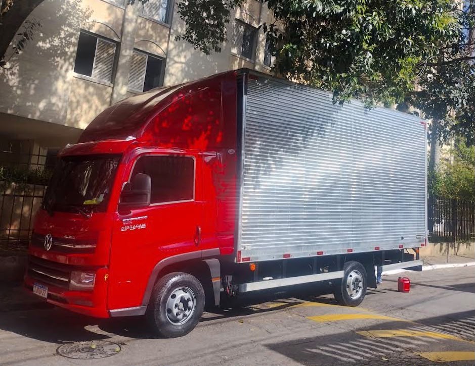 Caminhão vermelho de mudanças da Sergio Carretos e Mudanças estacionado em rua de São Paulo